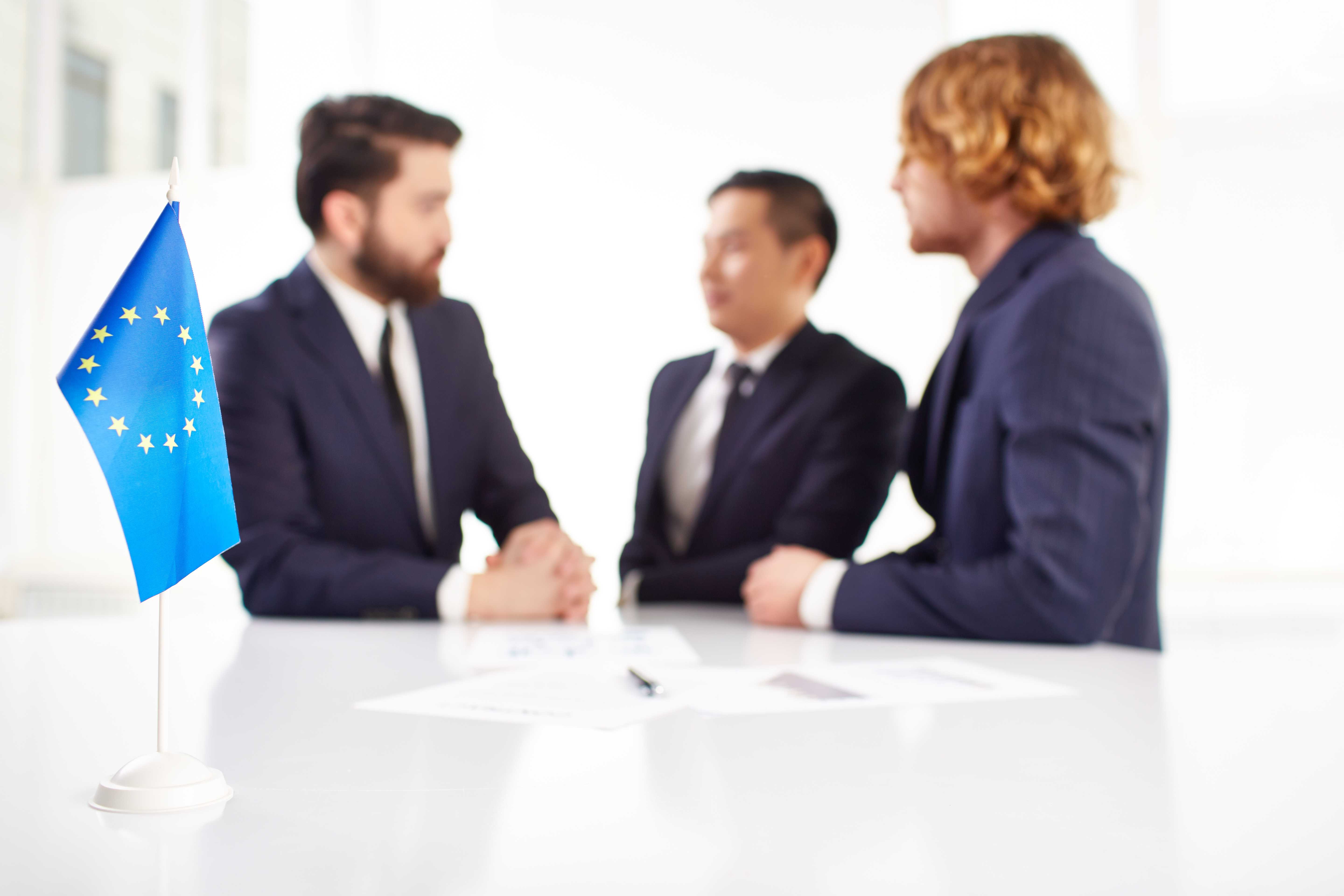 close-up-europe-flag-with-businessmen-background.jpg