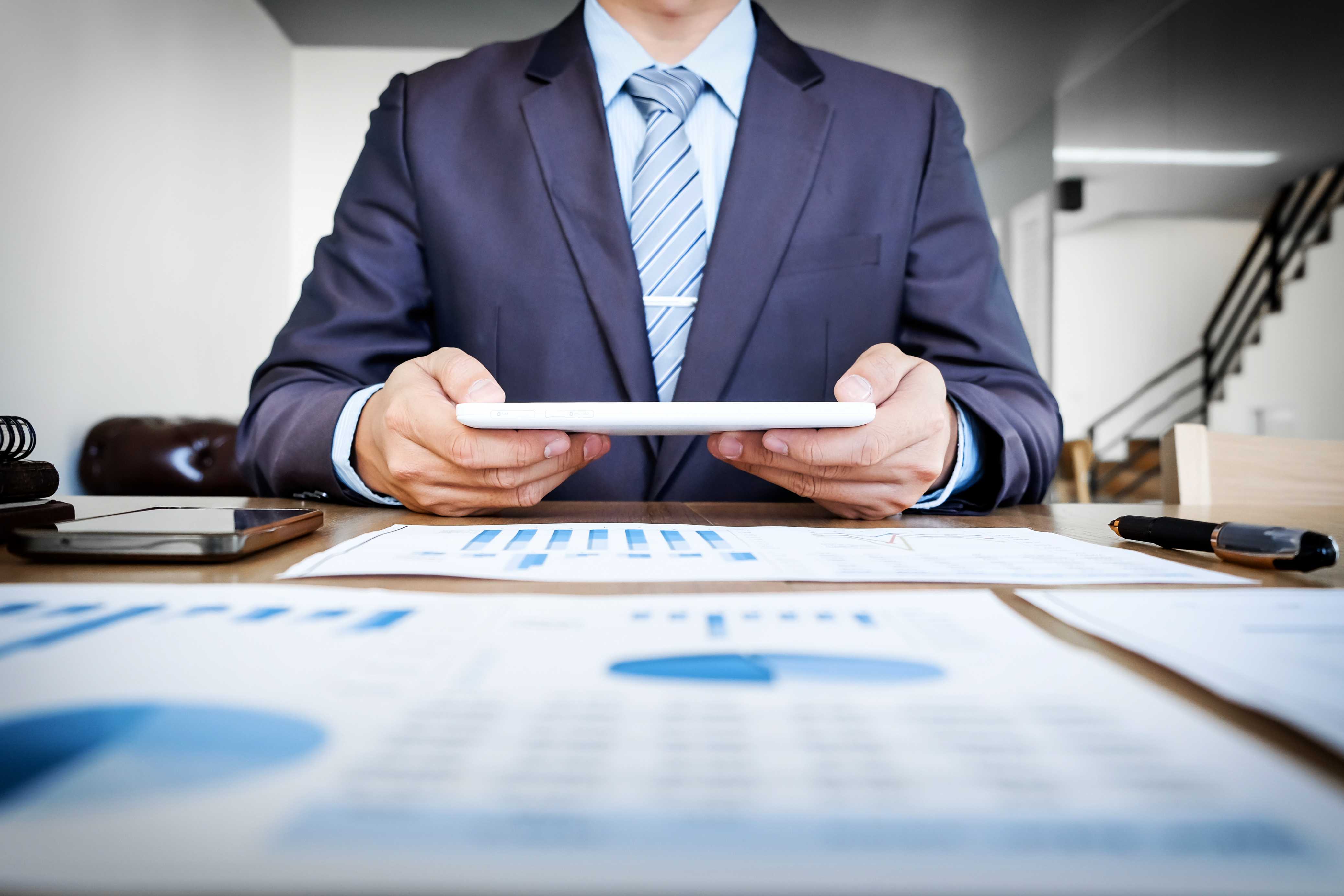 multitasking-handsome-young-man-working-with-touchpad-while-sitting-couch-office-financial-statistic-graph.jpg