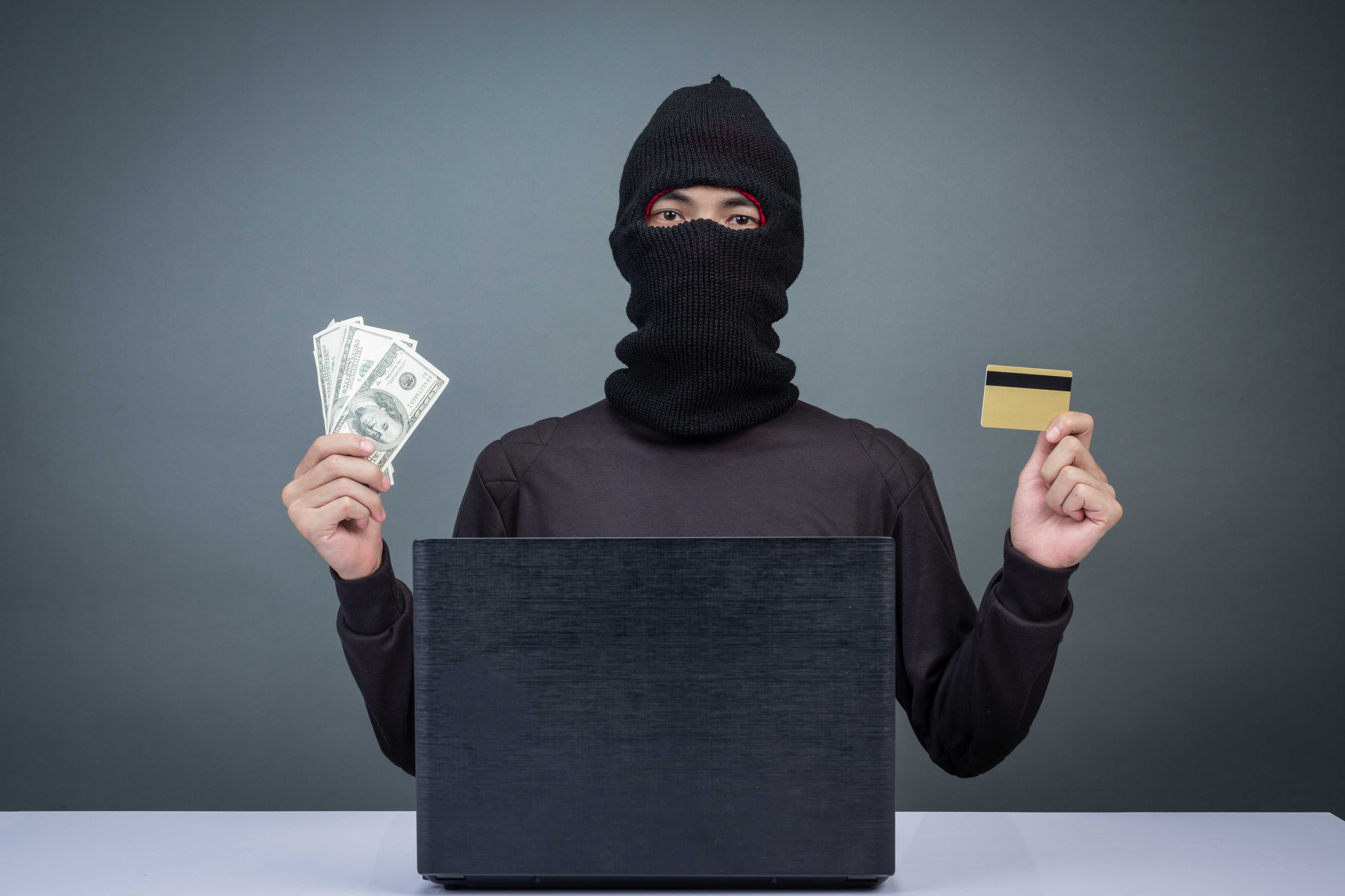 thieves-hold-credit-cards-using-laptop-computer-password-hacking-activities.jpg