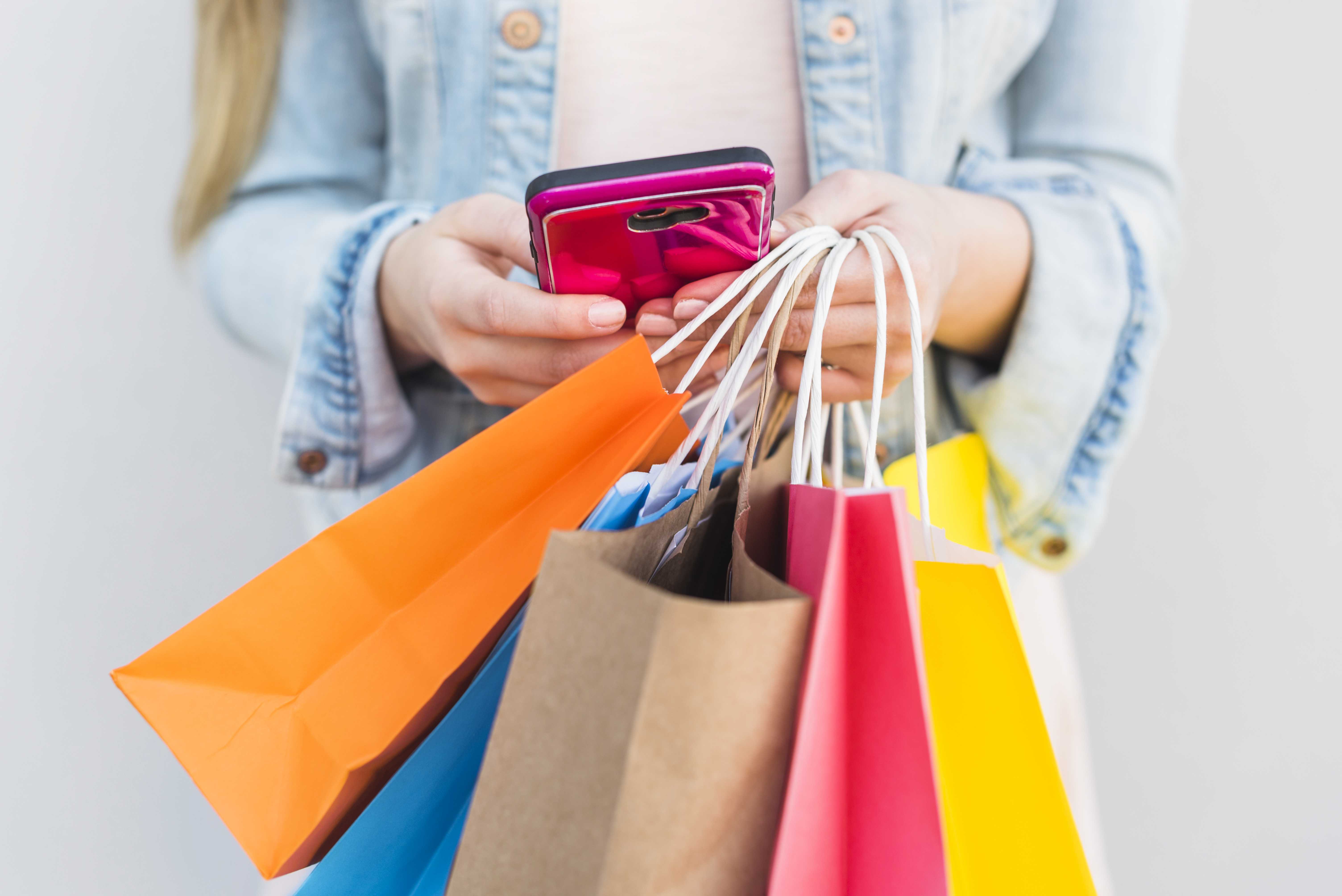 woman-with-bright-shopping-bags-using-smartphone.jpg